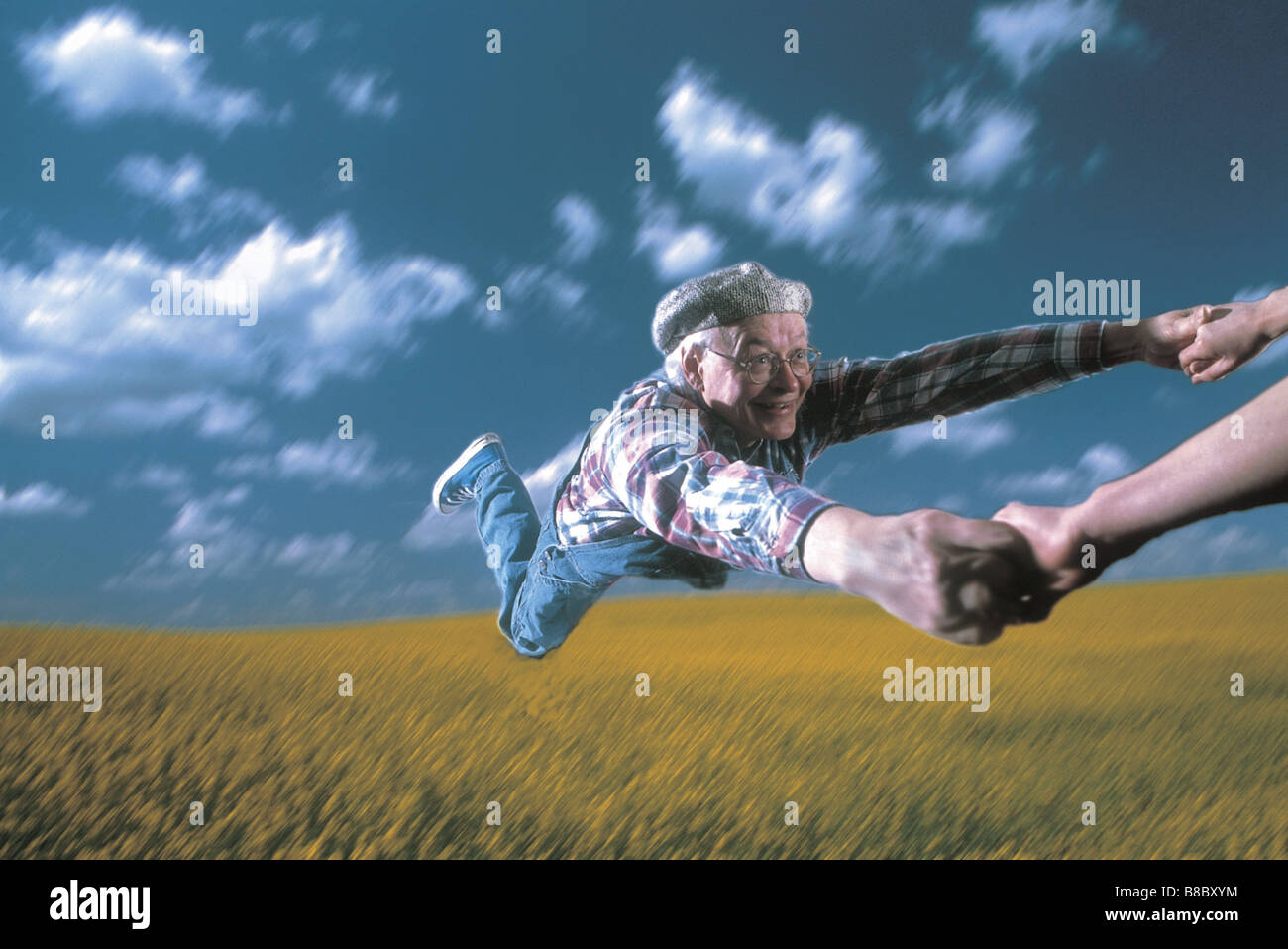 FL5027, Brian Milne; Senior Farmer wird geschwungen durch Luft durch seine Arme, Feld Hintergrund Stockfoto