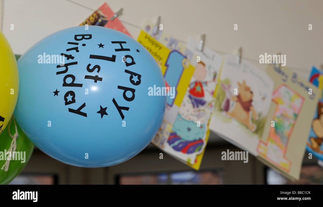 Froh, dass eine Wand, um den Jahrestag der einen kleinen Jungen auf einer Party feiern ersten Geburtstag Ballons und Karten hängen. Stockfoto