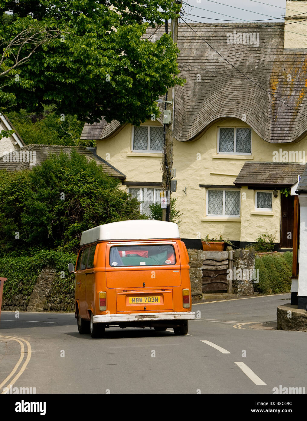 Ein VW-Campingbus Antriebe durch das Dorf croyde auf dem Weg zum Surfen Strand Stockfoto