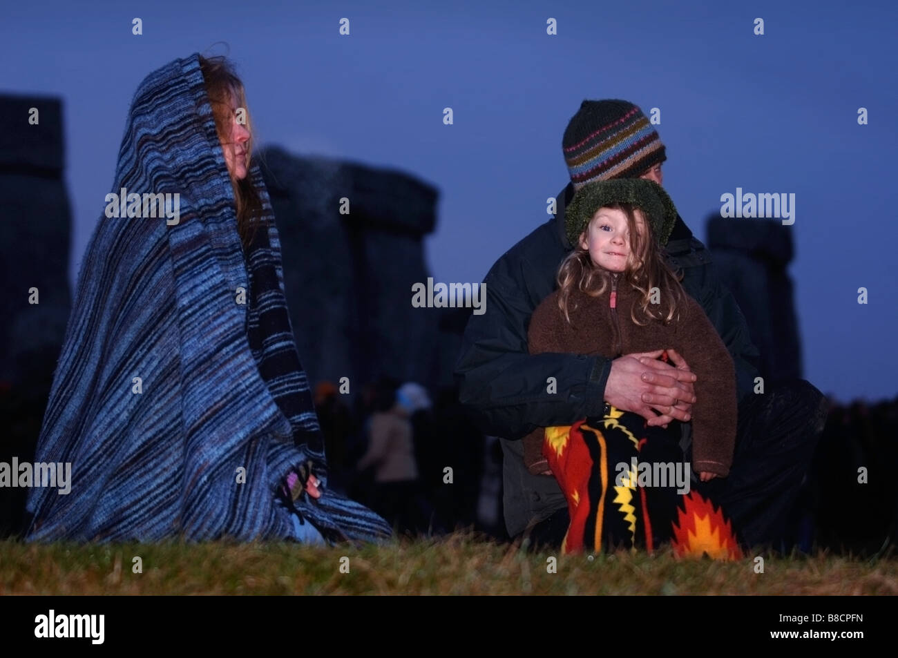 EINE FAMILIE UHR DEN SONNENAUFGANG IN STONEHENGE WÄHREND DER FEIERLICHKEITEN DER WINTERSONNENWENDE WILTSHIRE UK Stockfoto