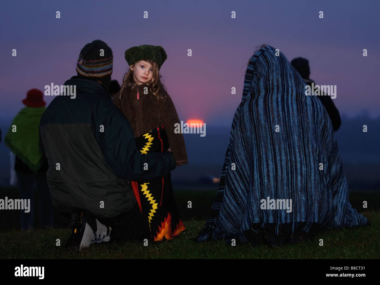 EINE FAMILIE UHR DEN SONNENAUFGANG IN STONEHENGE WÄHREND DER FEIERLICHKEITEN DER WINTERSONNENWENDE WILTSHIRE UK Stockfoto