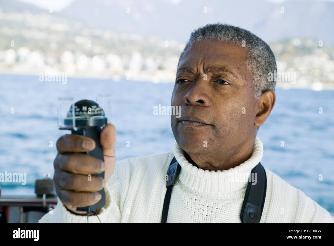 Ältere Menschen mit Sichtung Kompass sein Segelboot, Hafen Vancouver, BC Stockfoto