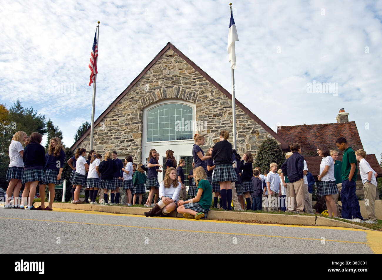 Studenten versammelten sich rund um den Fahnenmast an einer Privatschule. Stockfoto