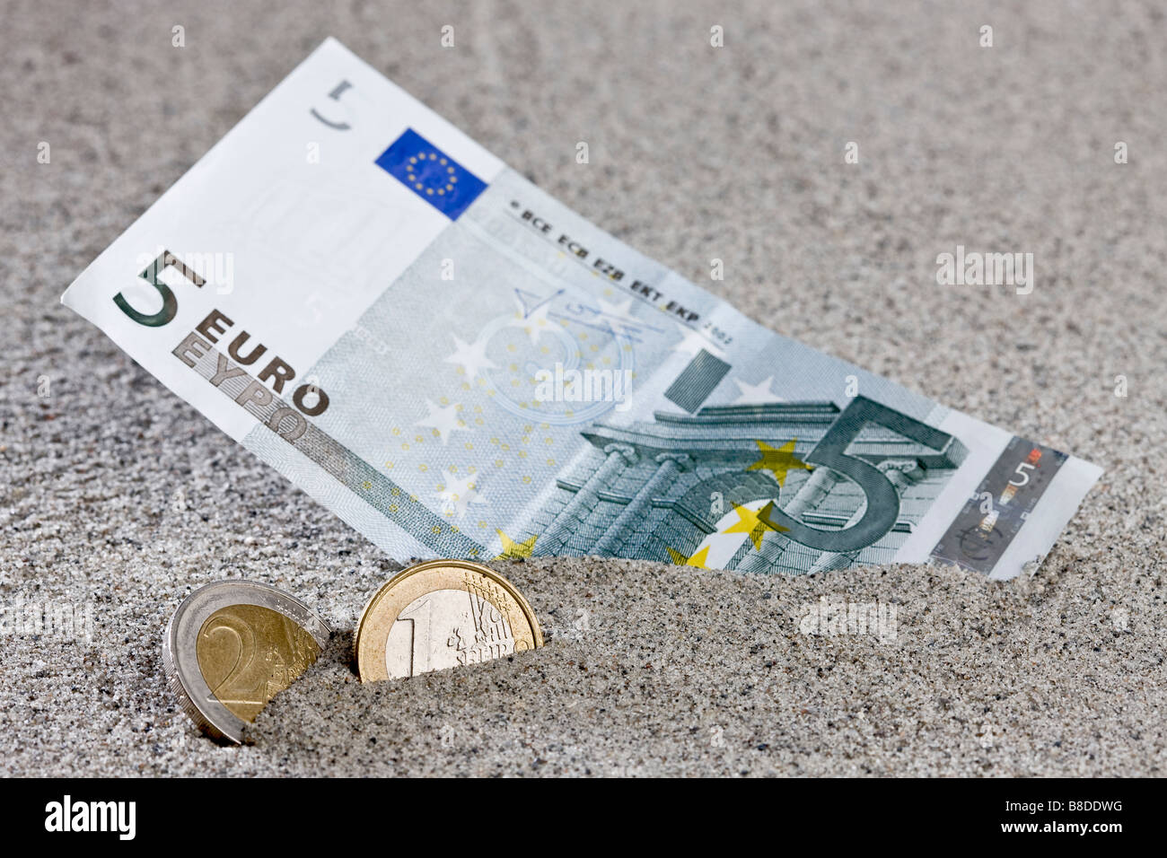 Acht Euro teilweise vergraben im Sand am Strand Stockfoto