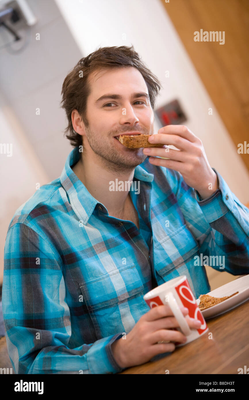 attraktiven Dressman liest die Morgenzeitung und trinken Tee, Kaffee, Frühstück Stockfoto