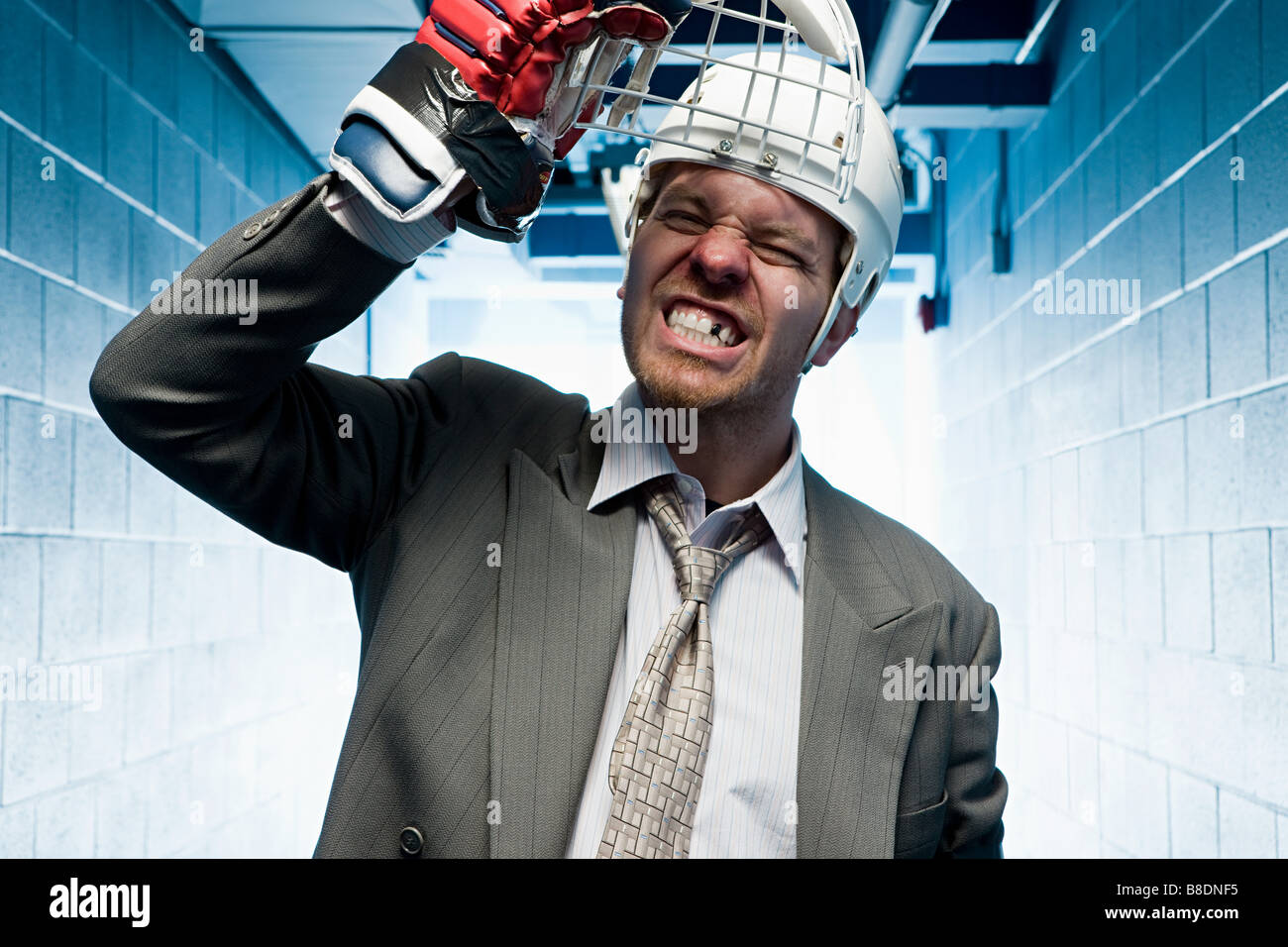 Grimassierende Geschäftsmann in einem Sportschutzhelm Stockfoto