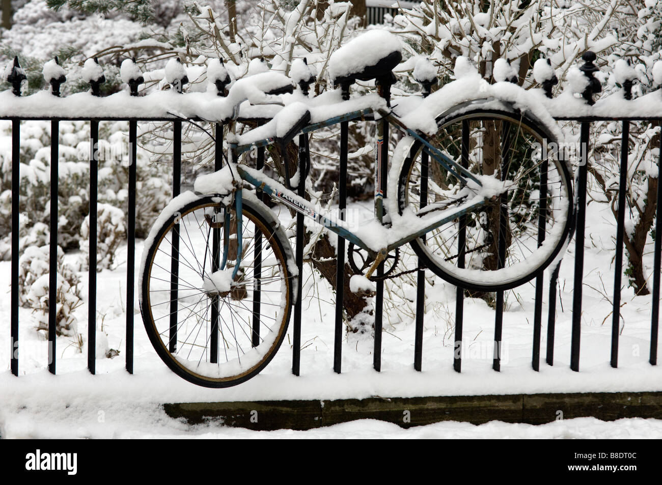 Ein Fahrrad verschneiten angebunden an viktorianischen Geländer in Brunswick Square Hove East Sussex Stockfoto