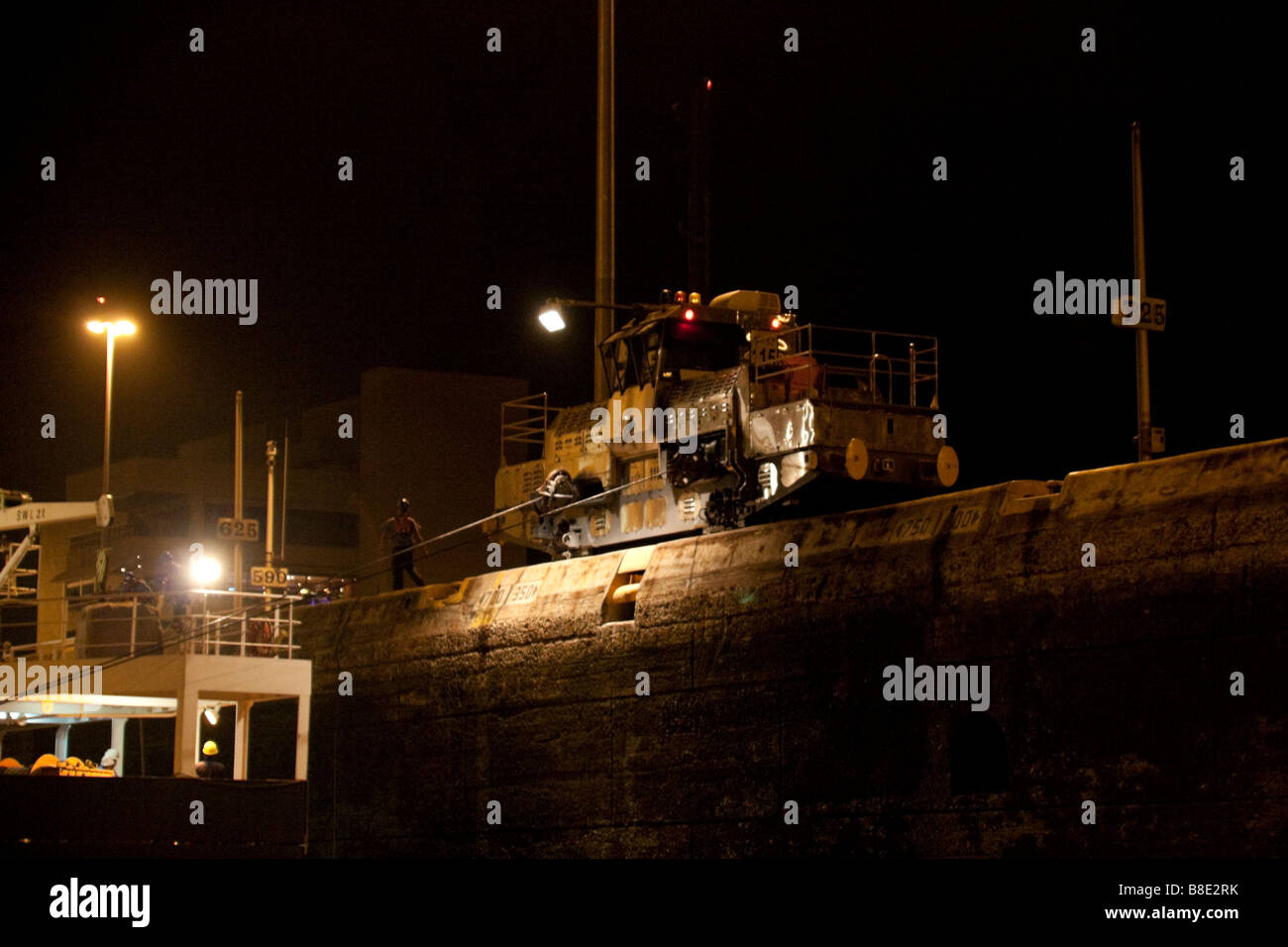 Panama-Kanal Maultier hilft Zentrierung eines Schiffes während eines Nacht Transits. Panamakanal, Panama City, Republik von Panama, Mittelamerika. Stockfoto