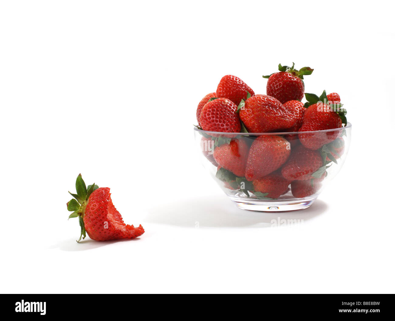 Schale mit roten Erdbeeren mit einem im Vordergrund gegessen Stockfoto