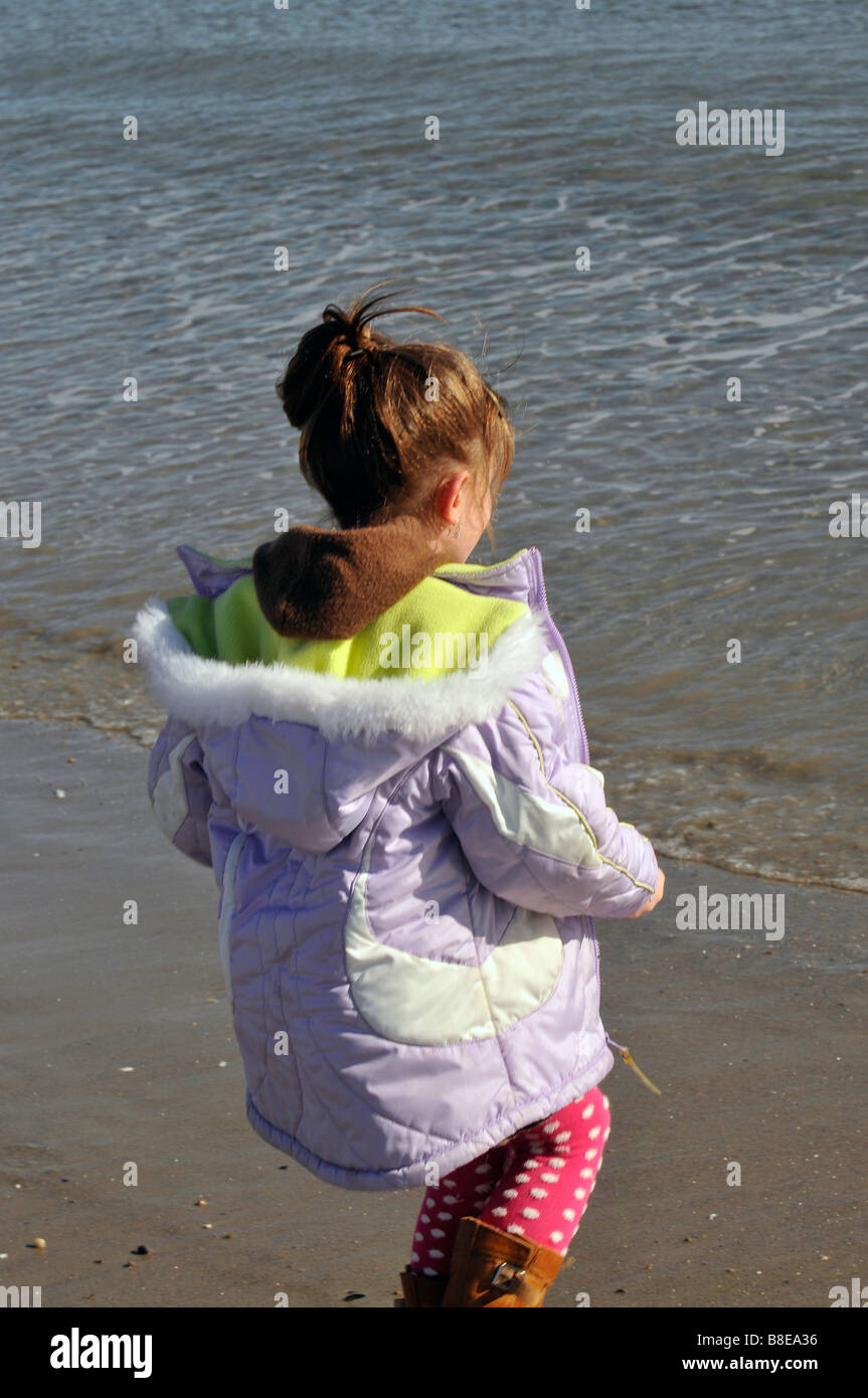 Junge Mädchen beobachten die Wellen am Rand des Wassers am salzigen Sole Beach in Rhode Island Stockfoto