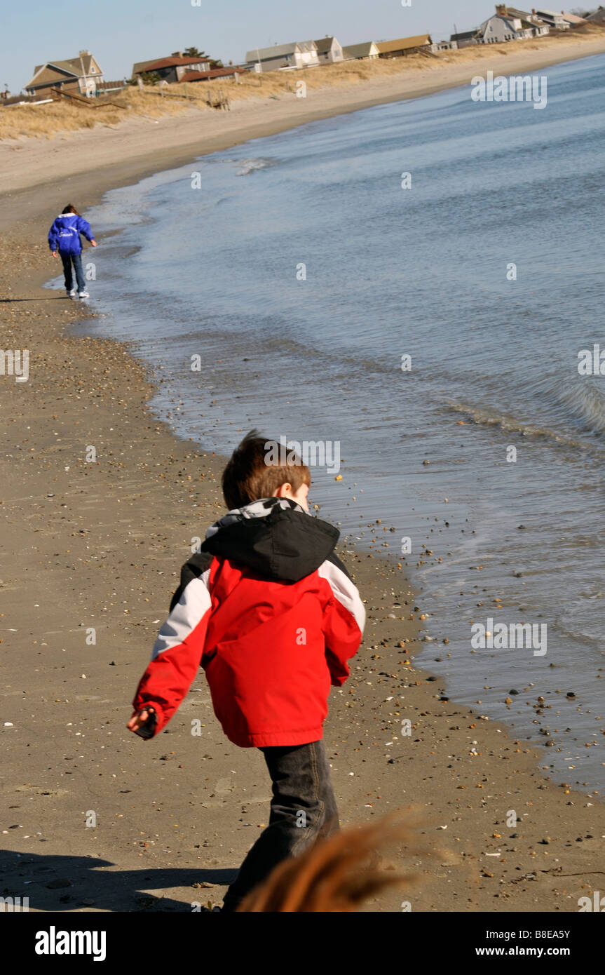 Junge werfen von Steinen ins Wasser auf salzigen Sole Strand in Rhode Island. Stockfoto