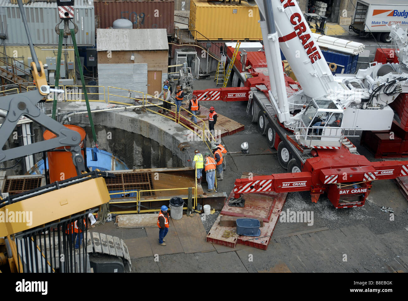 Bauarbeiter vorzubereiten, die 100-Tonnen-Schneidkopf von einer Tunnelbohrmaschine in einen Schacht in einem Plenarsaal zu senken Stockfoto