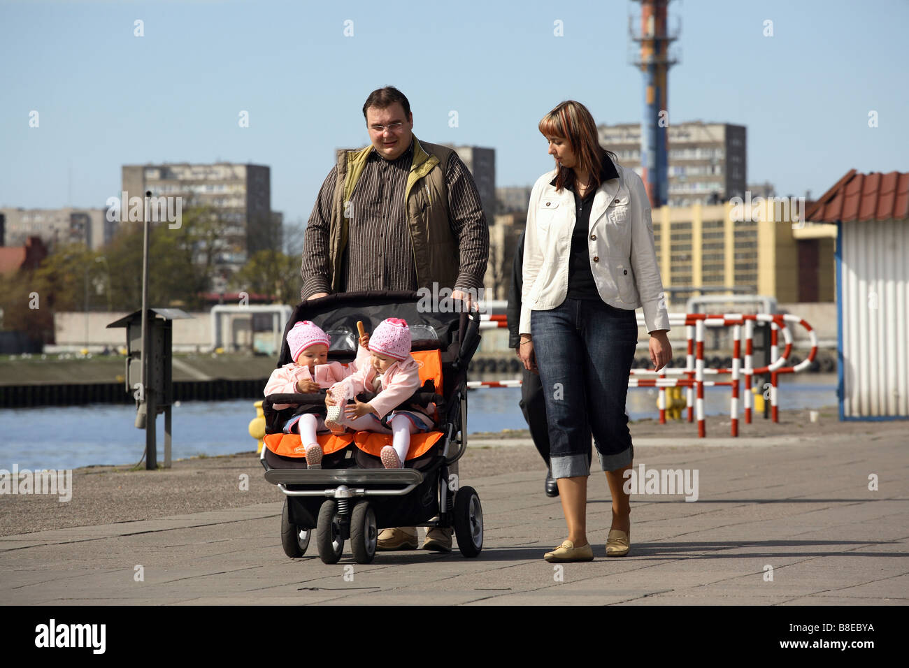 Eltern, die ein Spaziergang an einem Boulevard in Swinemünde mit Twin Kinderwagen, Polen Stockfoto