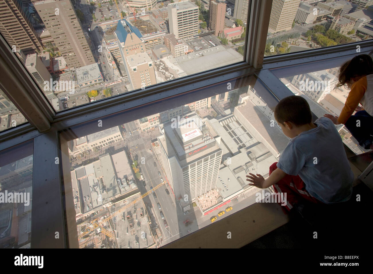 Kind Touristen nach unten durch den Glasboden, der Aussichtsplattform in Calgary Tower, Calgary, Alberta, Kanada Stockfoto