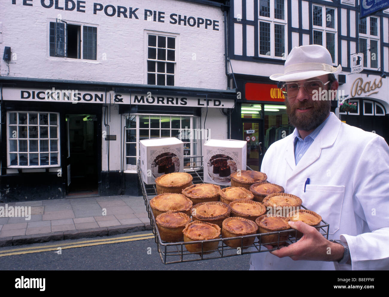 Ein Ladenbesitzer aus Ye Olde Pork Pie Shoppe in Melton Mowbray hält eine Anzeige der Schweinefleischpasteten und Melton Jagd Kuchen. Leicestershire. Stockfoto