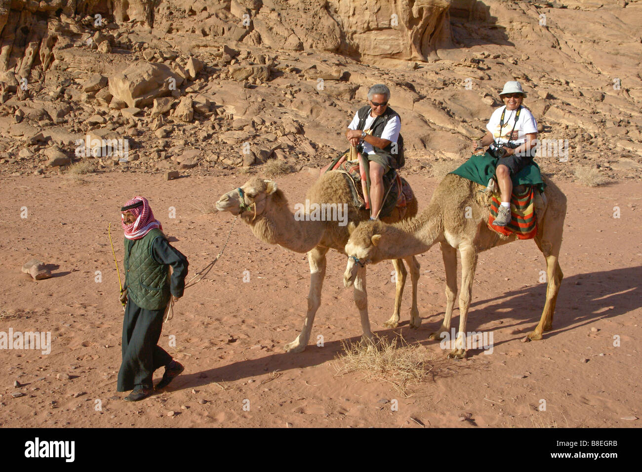 Touristen auf Kamelen im Wadi Rum, Jordanien Stockfoto