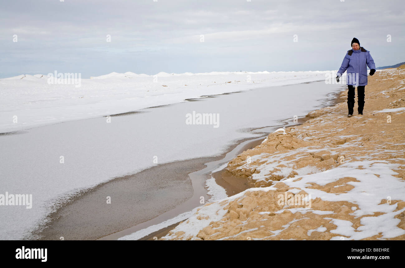 Frau Wanderungen am Ufer des Lake Michigan im Winter Stockfoto