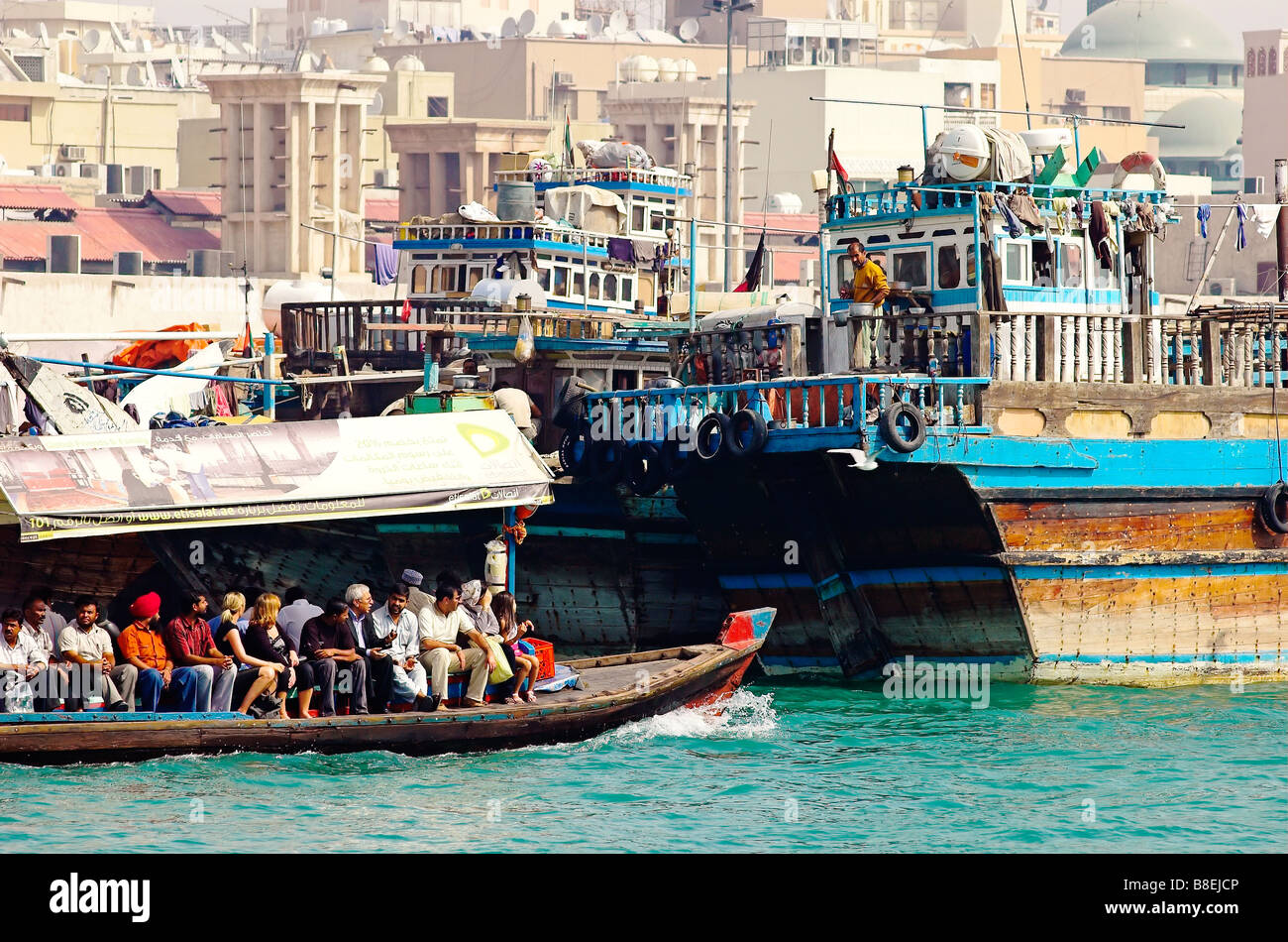 Wassertaxis nehmen Arbeitnehmer über den Bach, Dubai mit traditionellen Fracht Boote Daus Stockfoto