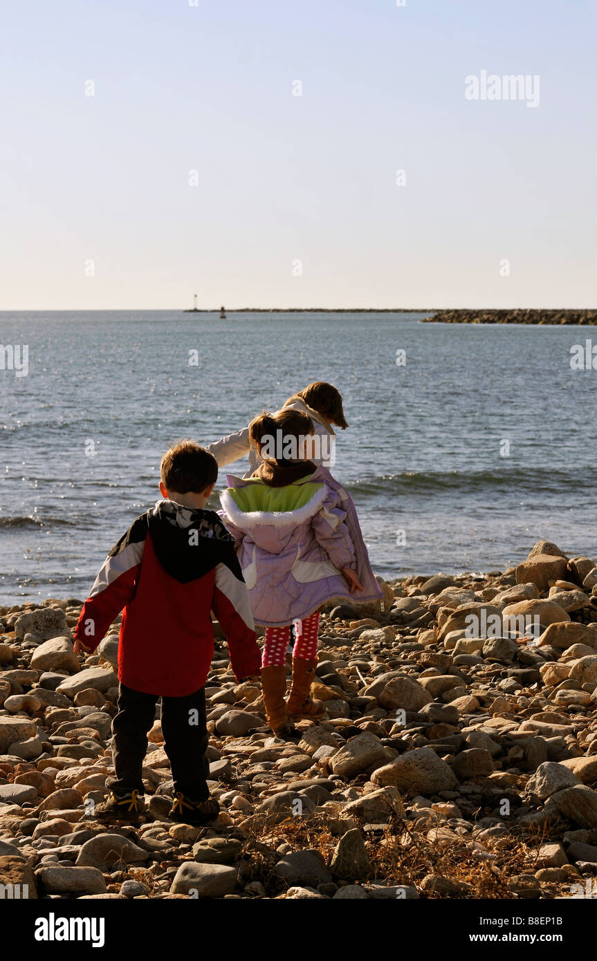 Drei Jugendliche Wandern und erkunden entlang der schroffen Felsenküste an Point Judith Lighthouse Stockfoto