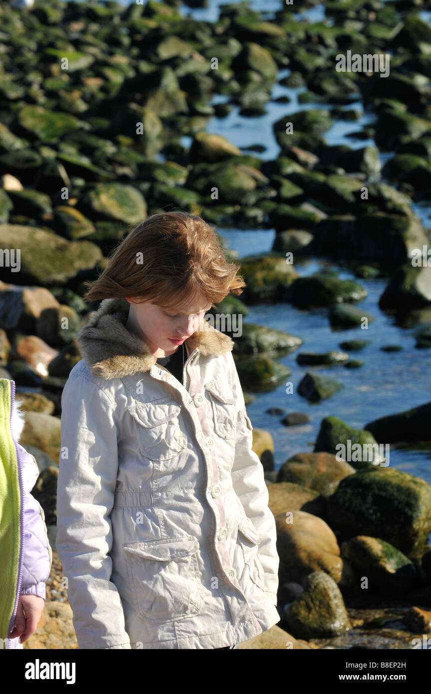 Junge Girld entlang der felsigen Küste zu einem Zeitpunkt Judith Lighthouse Stockfoto