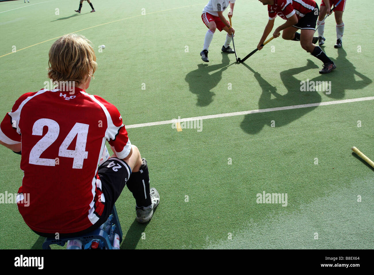 Ein deutscher Hockeyspieler auf einer Bank sitzen und beobachten das Spiel, Rüsselsheim, Deutschland Stockfoto