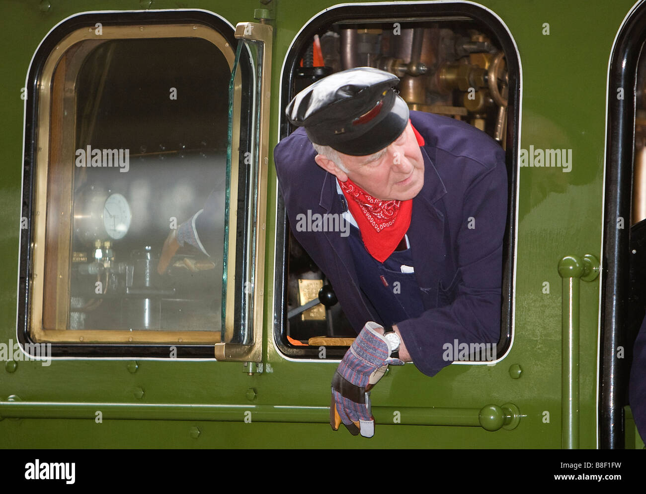 Der Zug Fahrer Ingenieur blickt zurück vom Führerstand einer Dampflokomotive Klasse A1 Peppercorn, wie er bei York Eisenbahn Sta kehrt Stockfoto