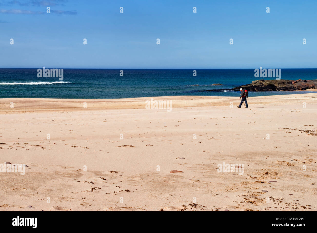 Einsamer Wanderer zu Fuß auf den isolierten uk Strand von Sandwood Bay in Schottland Stockfoto