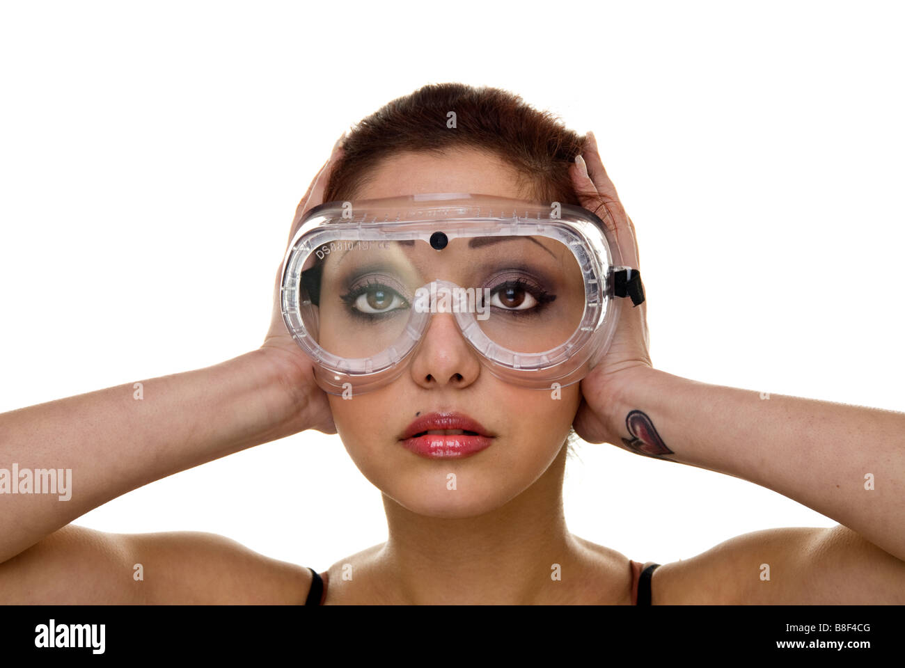 Frau trägt Schutzbrille mit Händen über ihre Ohren Stockfoto