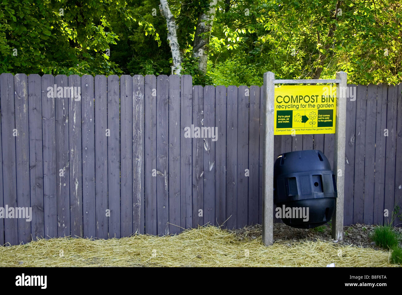 Ein Kompost entlang einem grauen Holzzaun Stockfoto