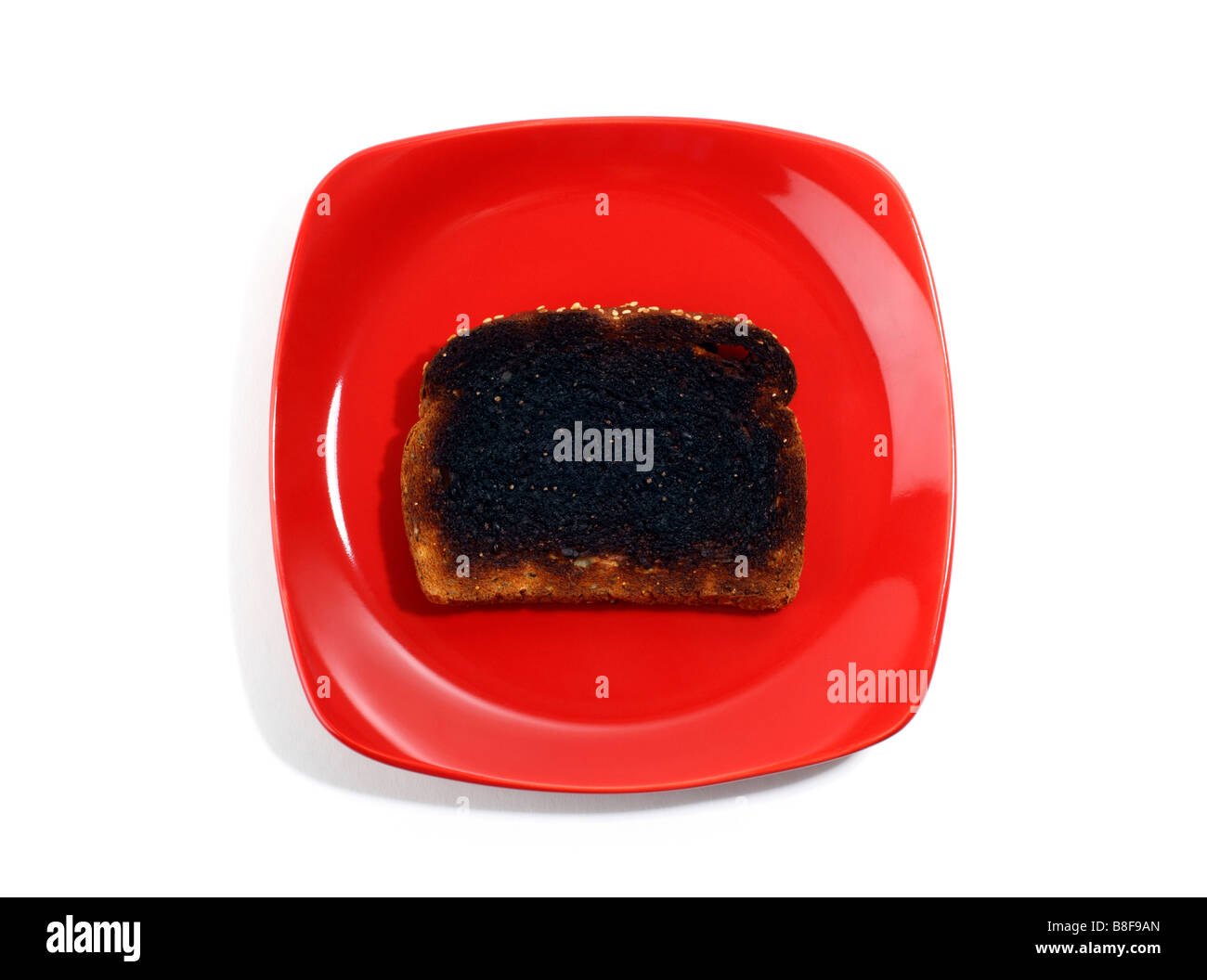 Verbranntem Toast auf rotem Teller Stockfoto