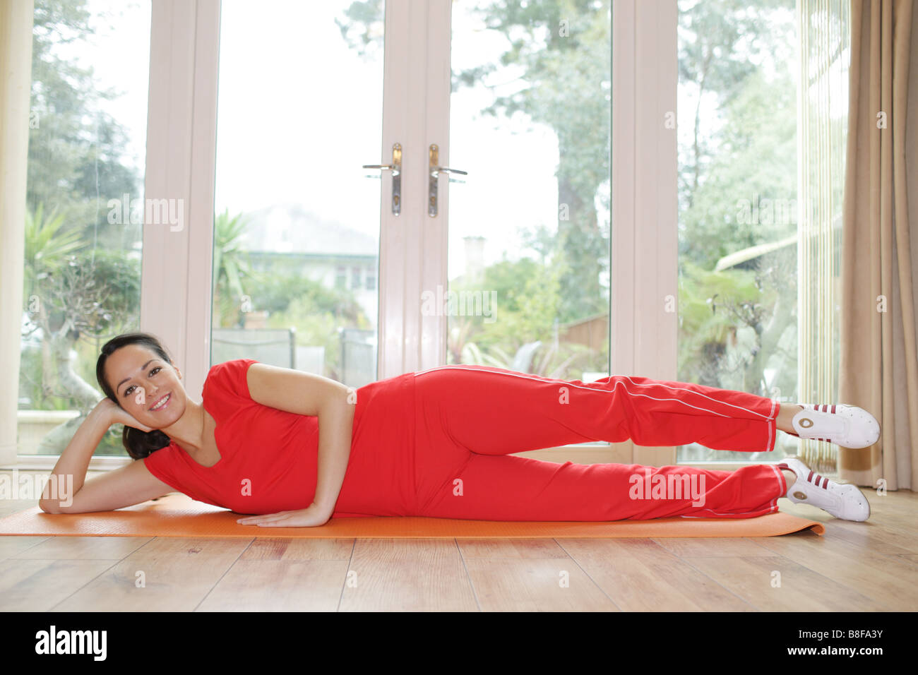 Junge Frau das Tragen der roten Sportswear Arbeiten, obwohl ein Fit halten oder Fitness Workout Routine Ihre Fitness und Gesundheit zu verbessern. Stockfoto