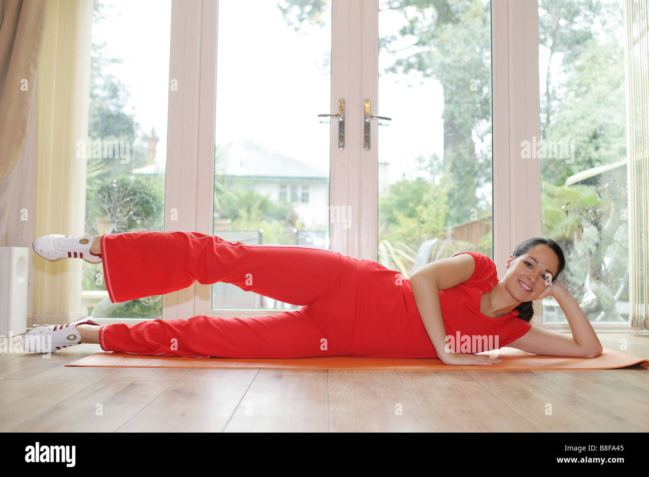 Junge Frau das Tragen der roten Sportswear Arbeiten, obwohl ein Fit halten oder Fitness Workout Routine Ihre Fitness und Gesundheit zu verbessern. Stockfoto