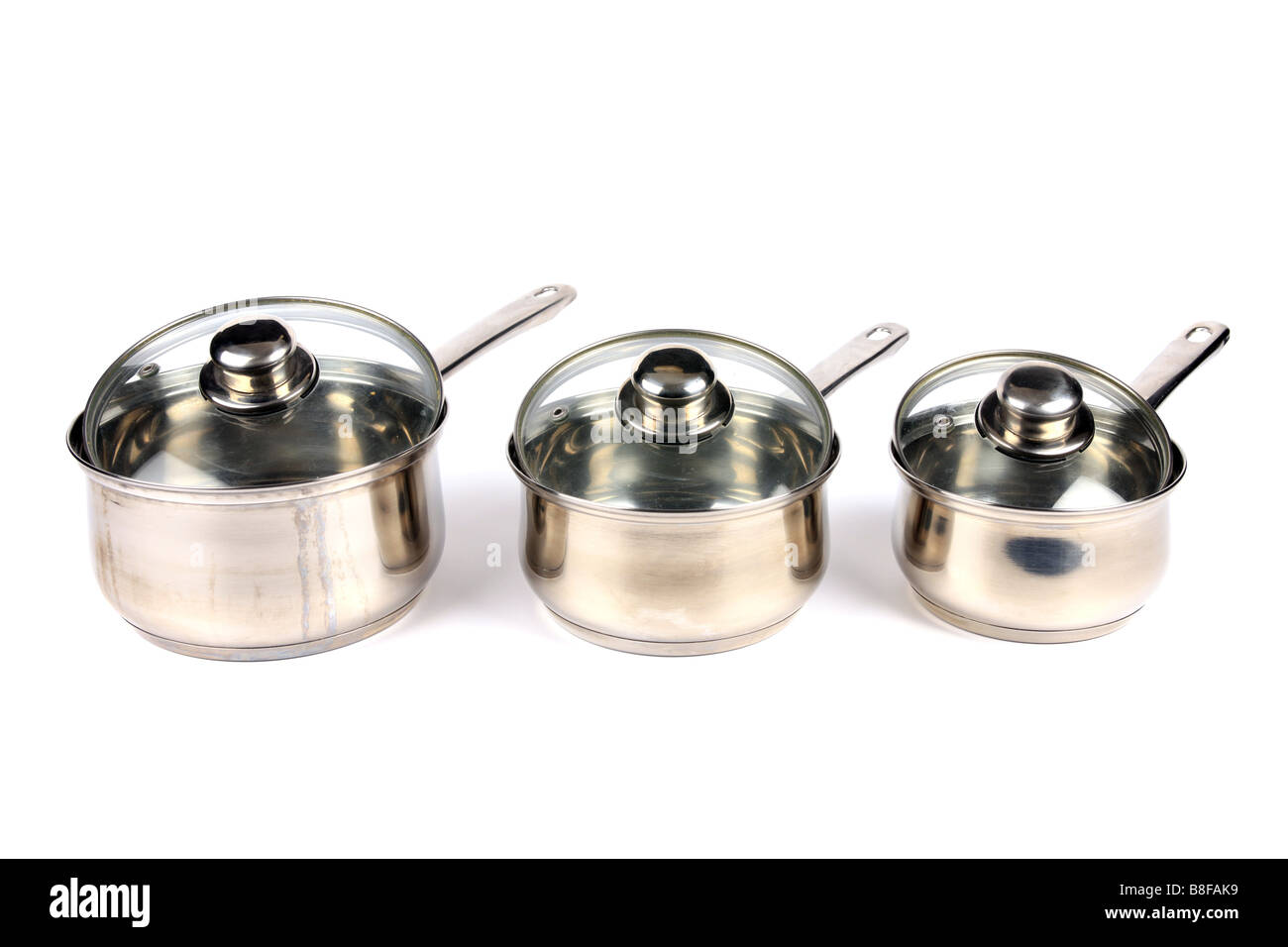Drei Edelstahl Kochtopf mit Glasdeckel vor einem weißen Hintergrund Stockfoto