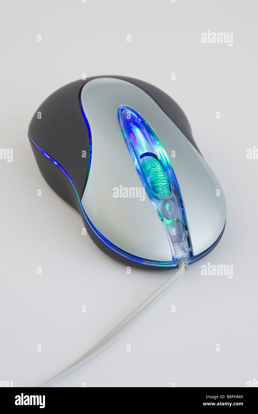 Kabelgebundene optische Computer-Maus auf eine schlichte Tischfläche beleuchtet Stockfoto