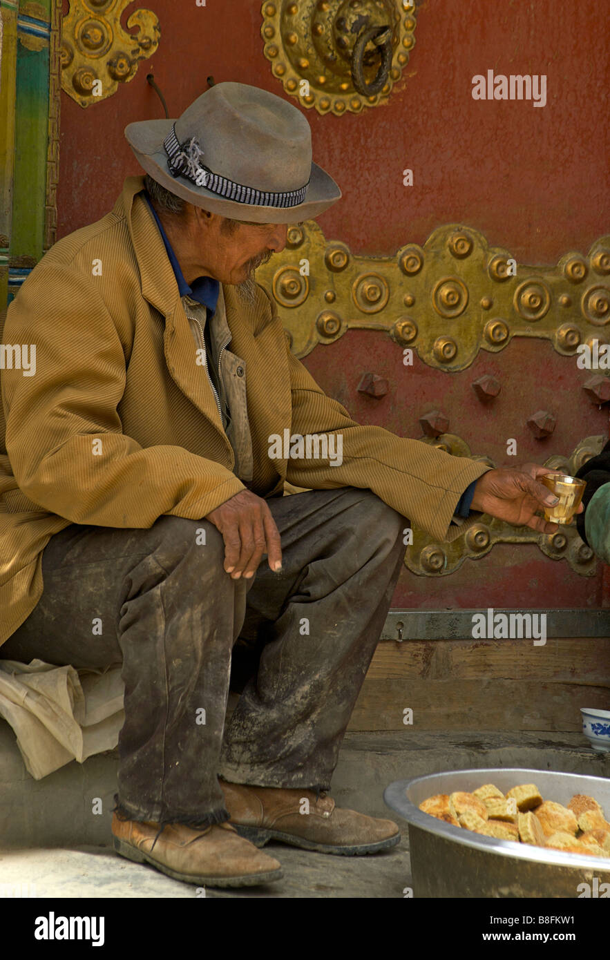 Tibetischen Menschen akzeptieren ein Getränk der Yak Buttertee in eine Tasse gegossen. Gyantse, Tibet Stockfoto