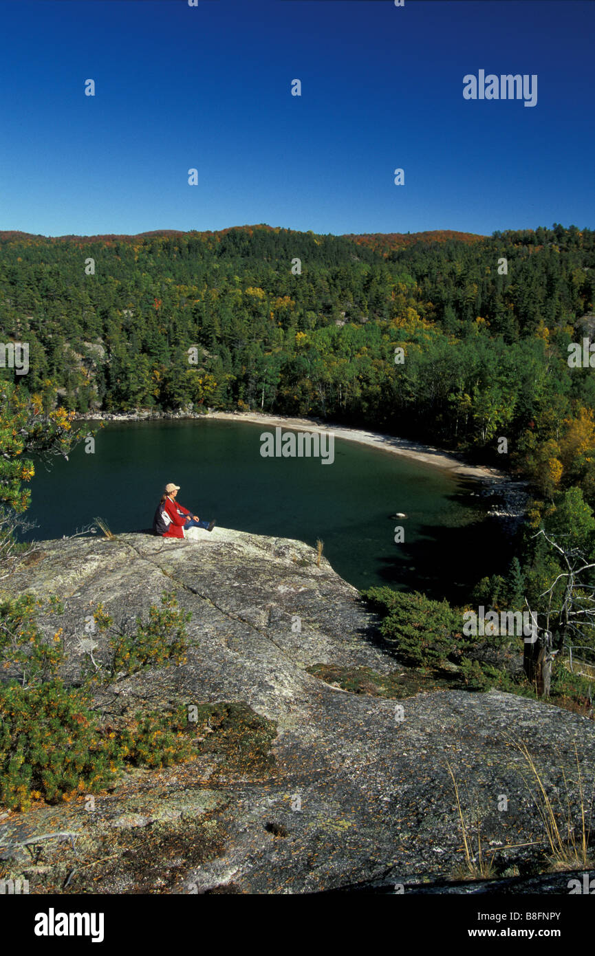 Mann sitzt auf einer Klippe mit Blick auf Sinclair Bucht des Lake Superior Stockfoto