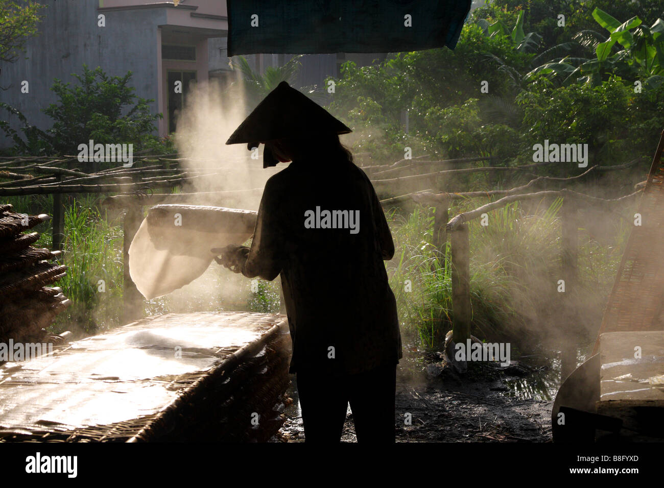 Frau mit der traditionellen konische Hut machen Reispapier. Mekong-Delta, Vietnam Stockfoto