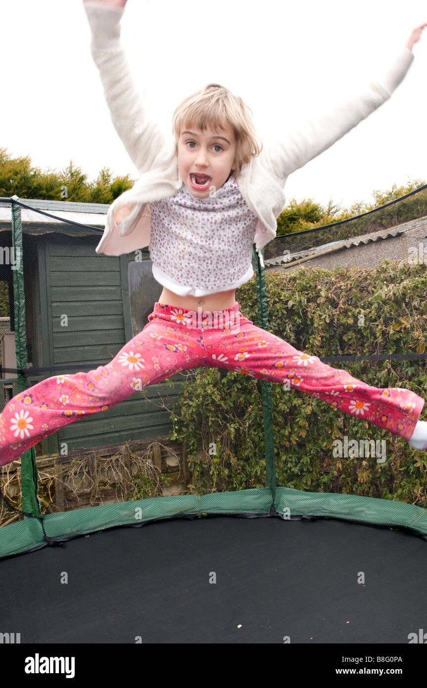 Ein sechs Jahres altes Mädchen springt auf einem Trampolin. Stockfoto