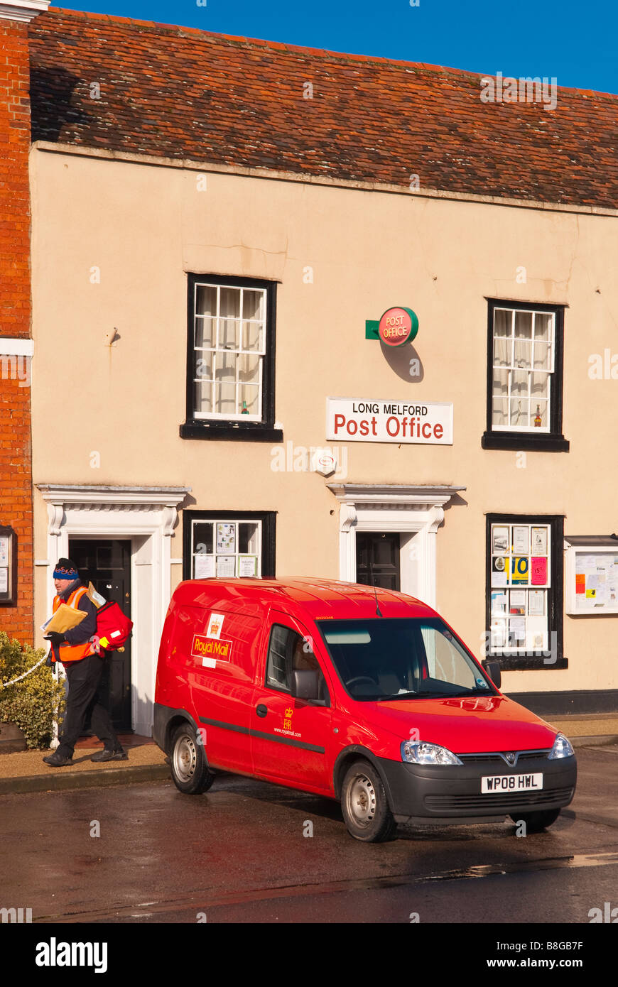 Das Postamt mit royal Mail van und Postboten auf seine Lieferung Runde im Vordergrund bei Long Melford, Suffolk, Uk Stockfoto