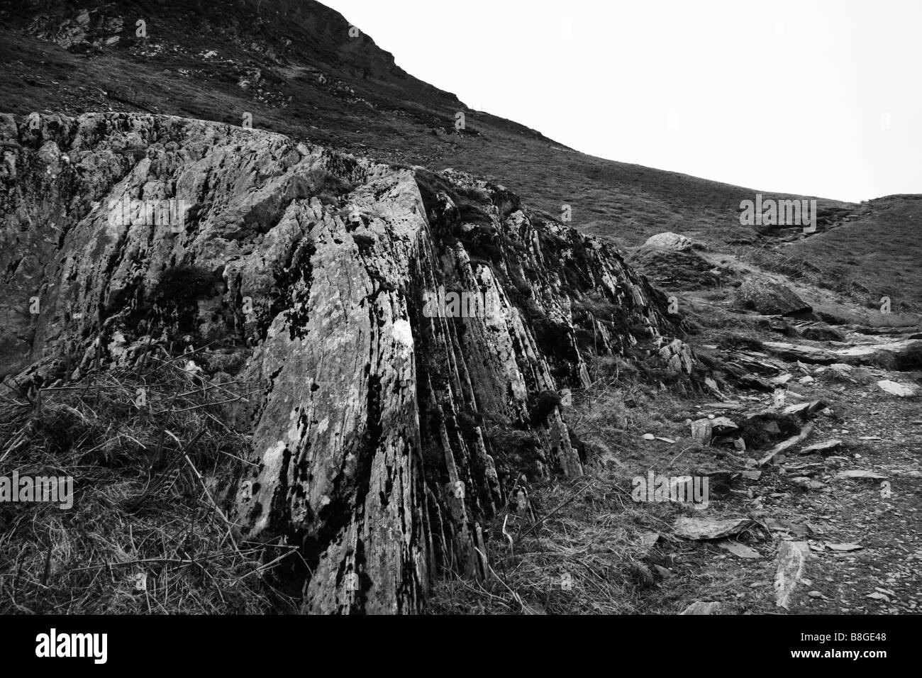 Einem großen Felsbrocken im Blick auf die zerklüftete Landschaft im Lake District in schwarz / weiß Stockfoto