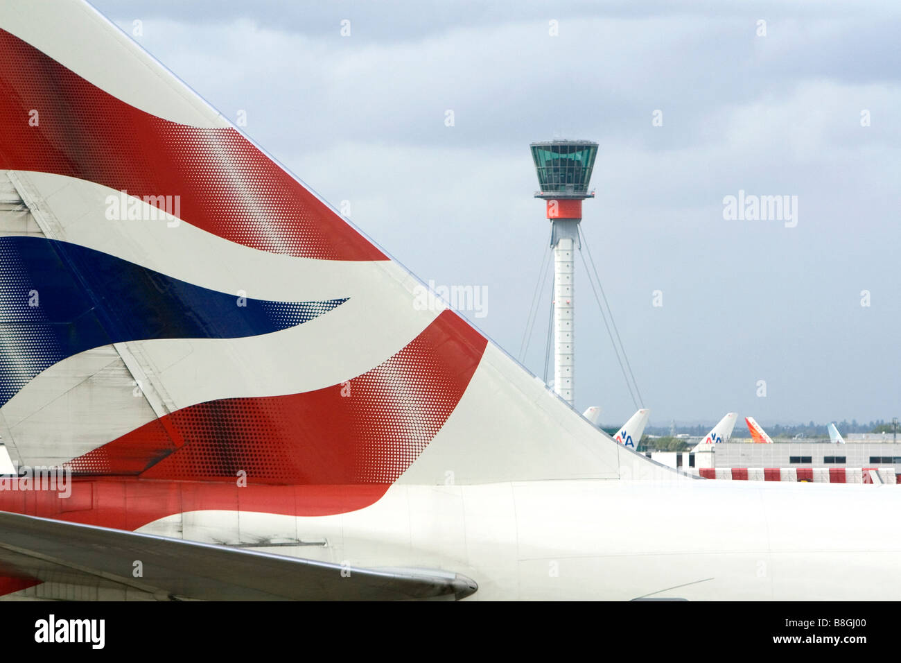 Verkehrsflugzeug Tail und Kontrollturm am London Heathrow Airport England Großbritannien Stockfoto