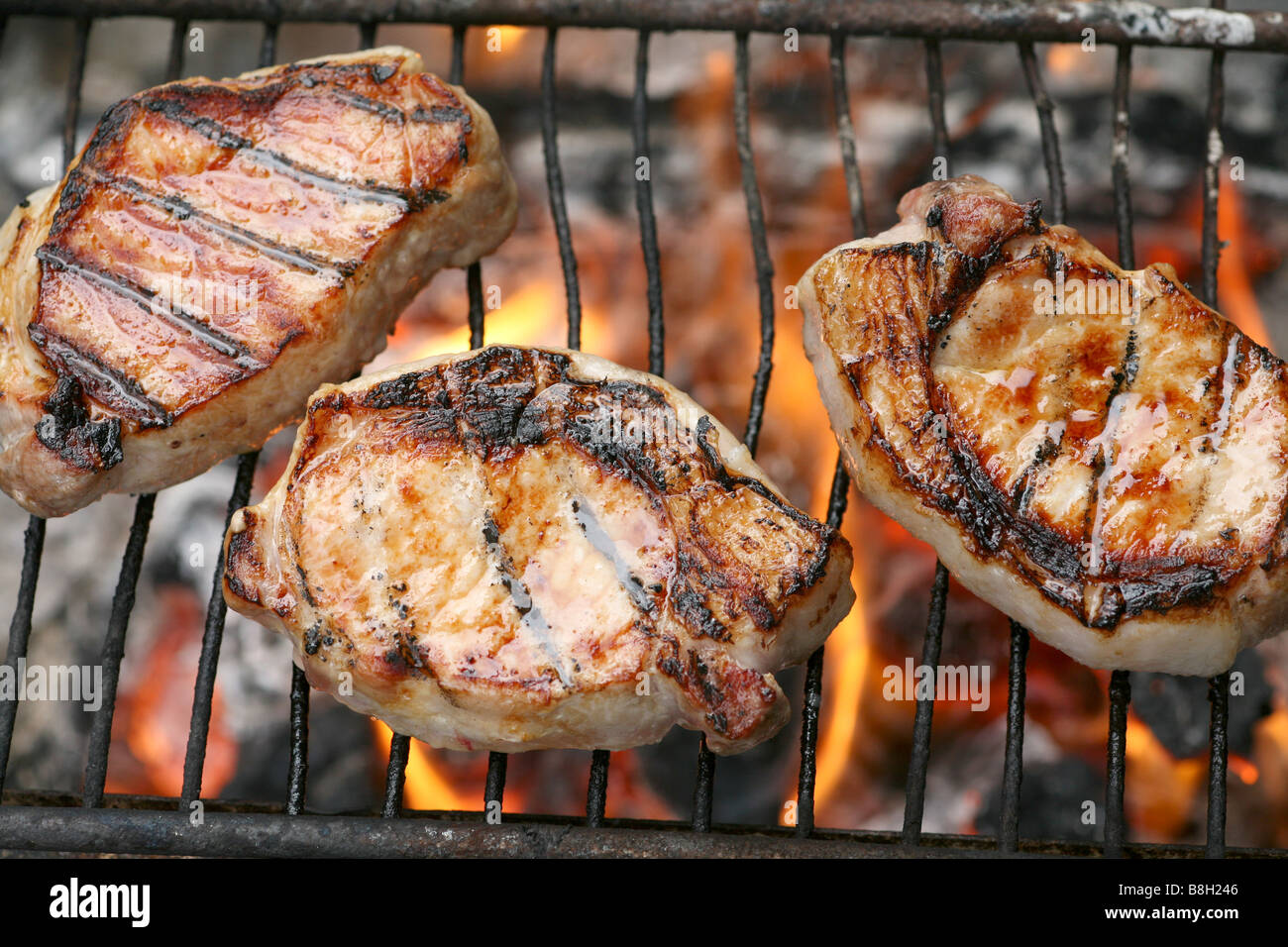 Bangalow Schweinekoteletts Grillen über offenem Feuer Stockfoto