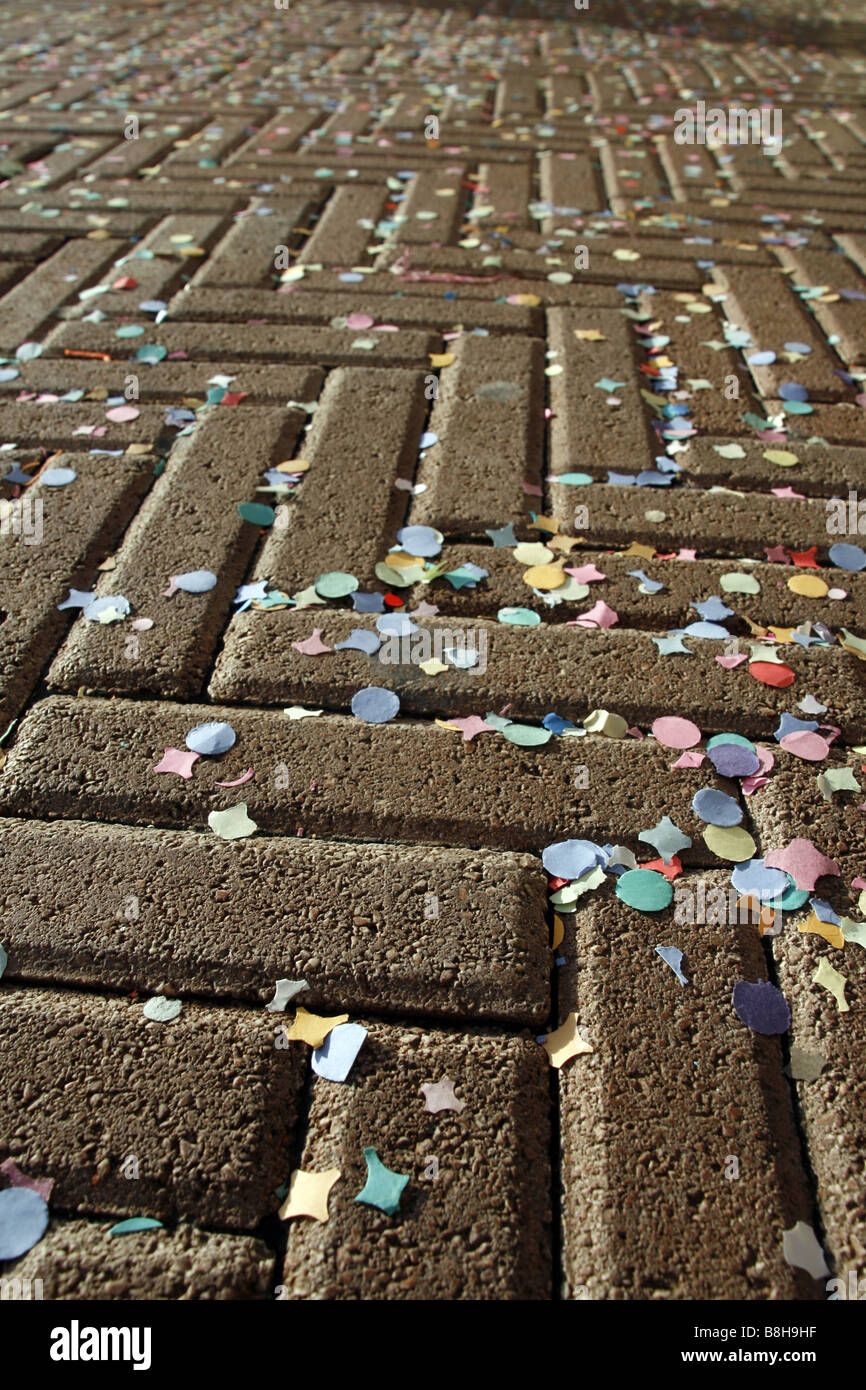 viele bunte Konfetti und Girlanden auf asphaltierten Straße Straße in Sonne Stockfoto