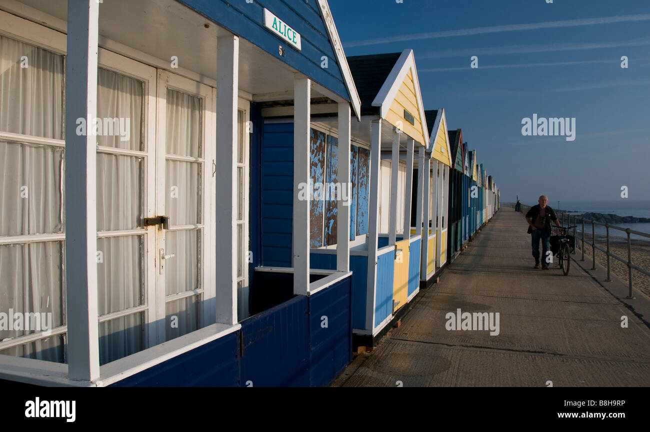 Mann geht Vergangenheit bunte hölzerne Strand Southwold, Suffolk UK Hütten Stockfoto