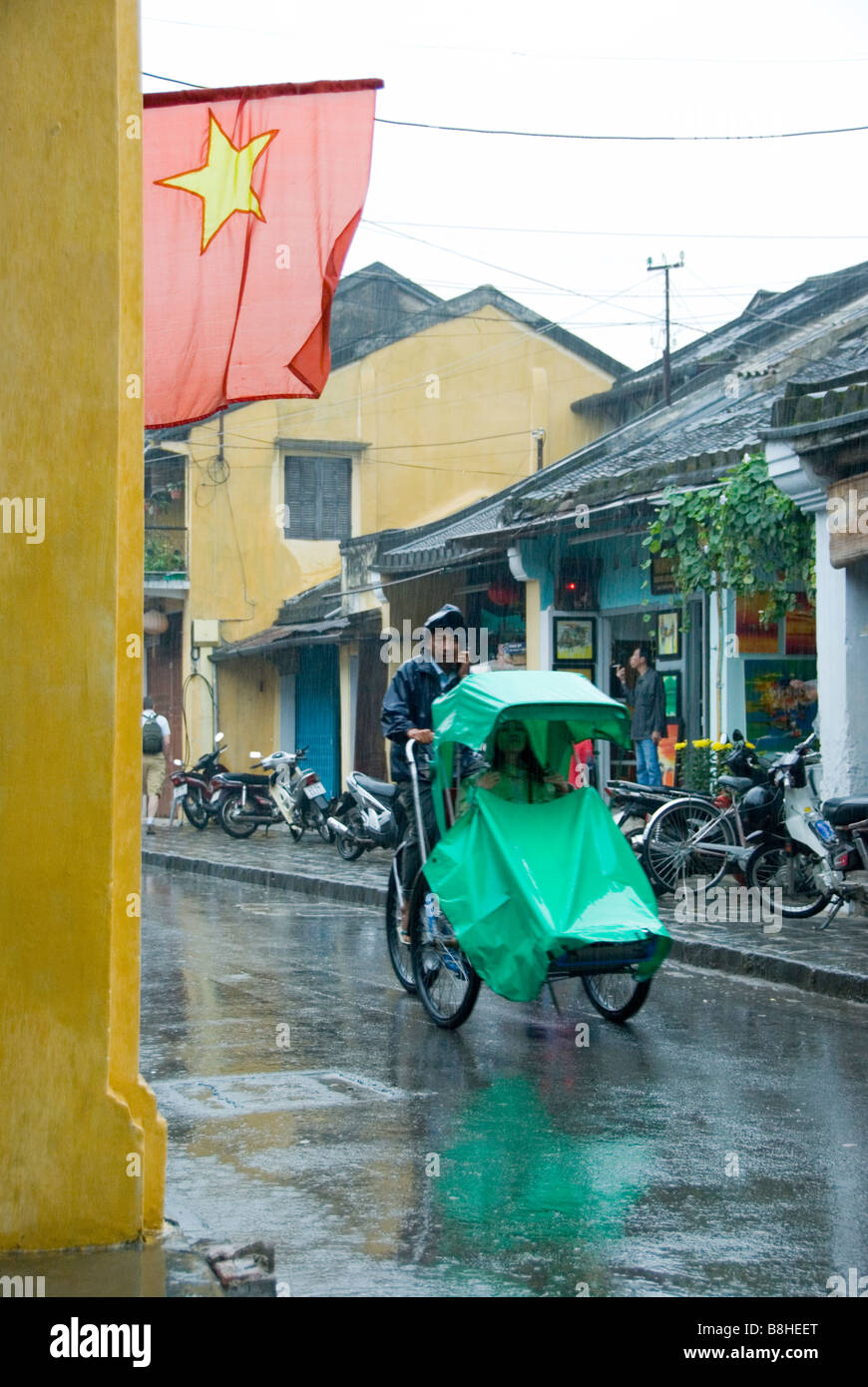 Radfahren durch den Regen Hoi An Vietnam Stockfoto