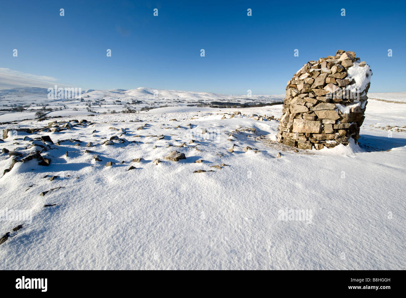 Schnee bedeckt Stein Cairn auf Asche fiel Rand in der Nähe von Ravenstonedale auf der Suche über den Nord-östlichen Rand des Howgill Fells Cumbria Stockfoto