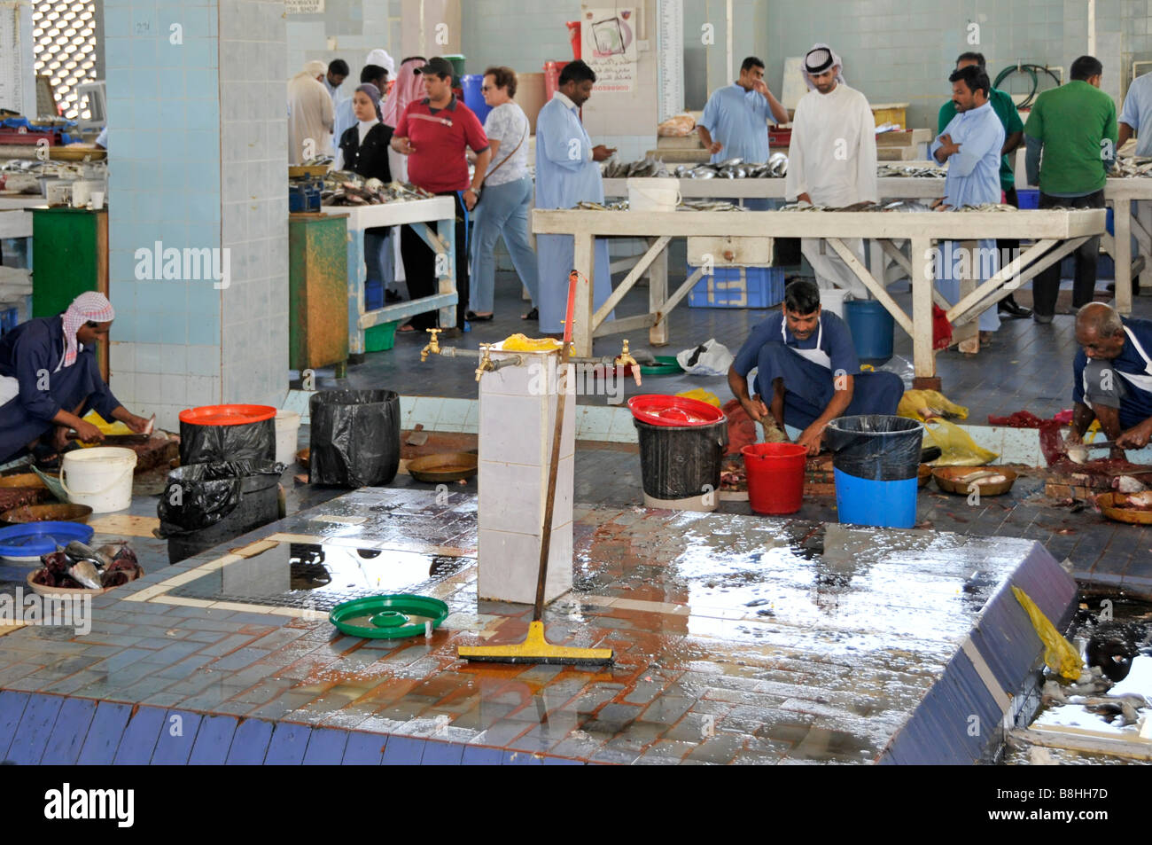 Arbeiter, die auf dem Fischmarkt von Fujairah sitzen, um den jüngsten Fang im Emirat Fujairah an der Ostküste der Vereinigten Arabischen Emirate vorzubereiten Stockfoto