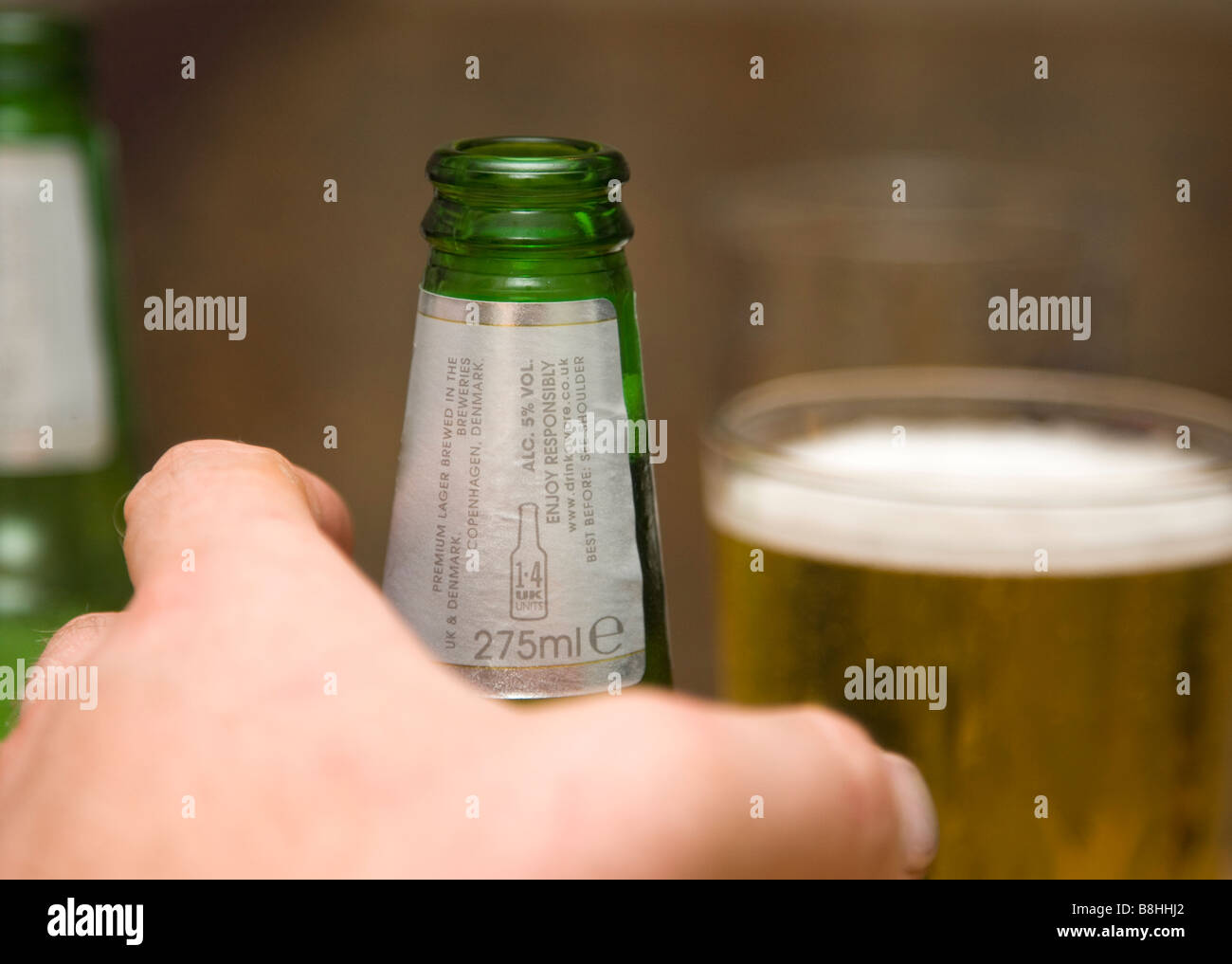 Eine Person für einen Schluck Alkohol zu erreichen. Stockfoto