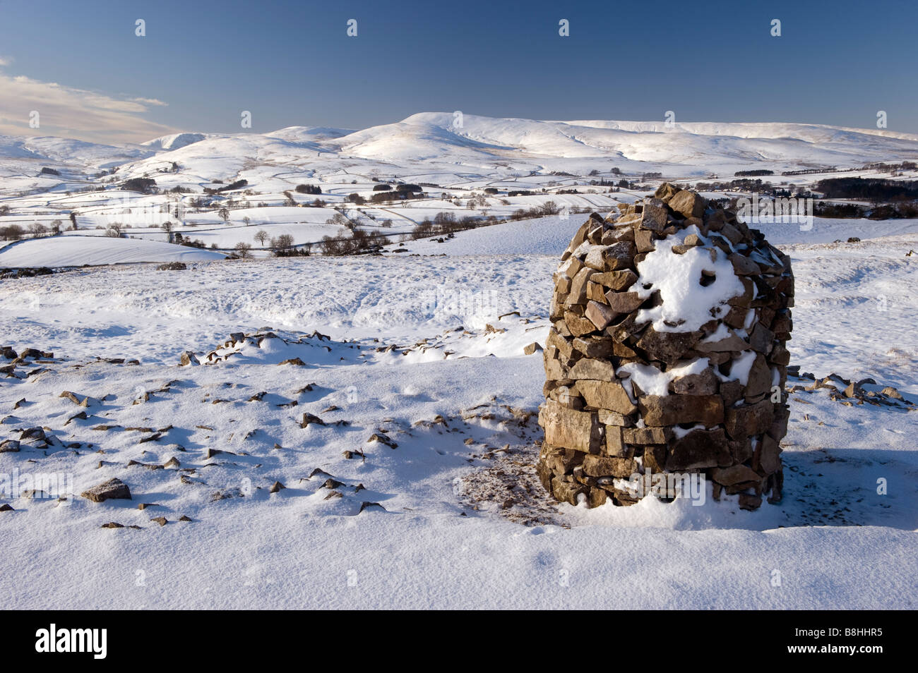 Schnee bedeckt Stein Cairn auf Asche fiel Rand in der Nähe von Ravenstonedale auf der Suche über den Nord-östlichen Rand des Howgill Fells Cumbria Stockfoto