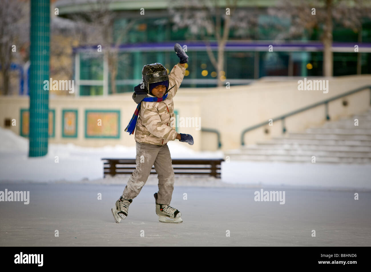 Young African American Boy, Schlittschuh, Outdoor-Eisbahn zu lernen. Stockfoto